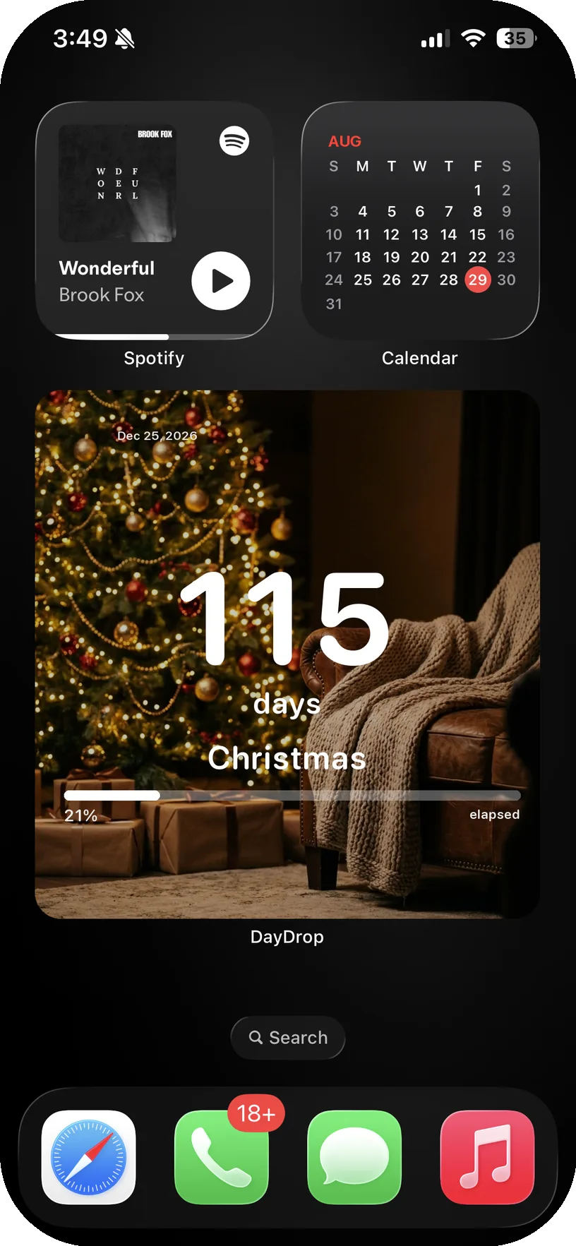 Real iPhone Home Screen with a large DayDrop widget showing 115 days until Christmas over an AI-generated Christmas tree background, next to Spotify and Calendar widgets